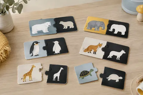 Puzzles duo illustrés d’animaux, assemblés et séparés sur une table en bois clair.