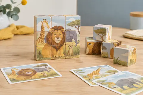 Neuf cubes en bois illustrés d’animaux et leurs cartes modèles disposés sur une table claire.